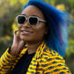 Black woman wearing gray wayframe sunglasses made of silver oak with subtle black wood grain accents with dark gray lenses by NURILENS.