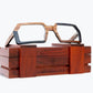 Brown and black rectangular wooden glasses made of black birch and brown kevazingo wood sitting on rosewood wooden case by NURILENS.