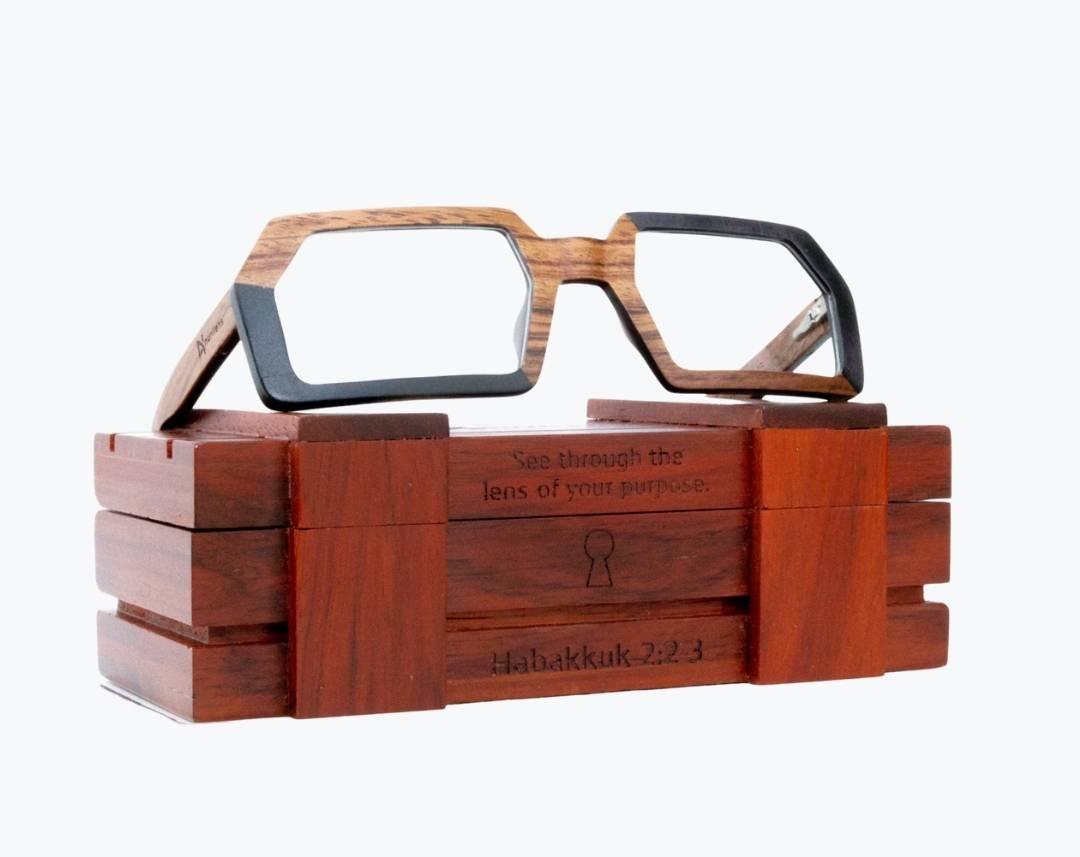 Brown and black rectangular wooden glasses made of black birch and brown kevazingo wood sitting on rosewood wooden case by NURILENS.