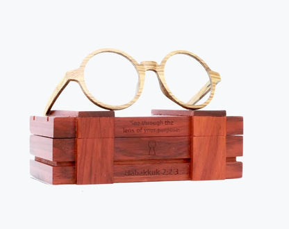 Round wooden glasses made of light brown Zebrawood with subtle black stripes sitting on rosewood wooden case by NURILENS.